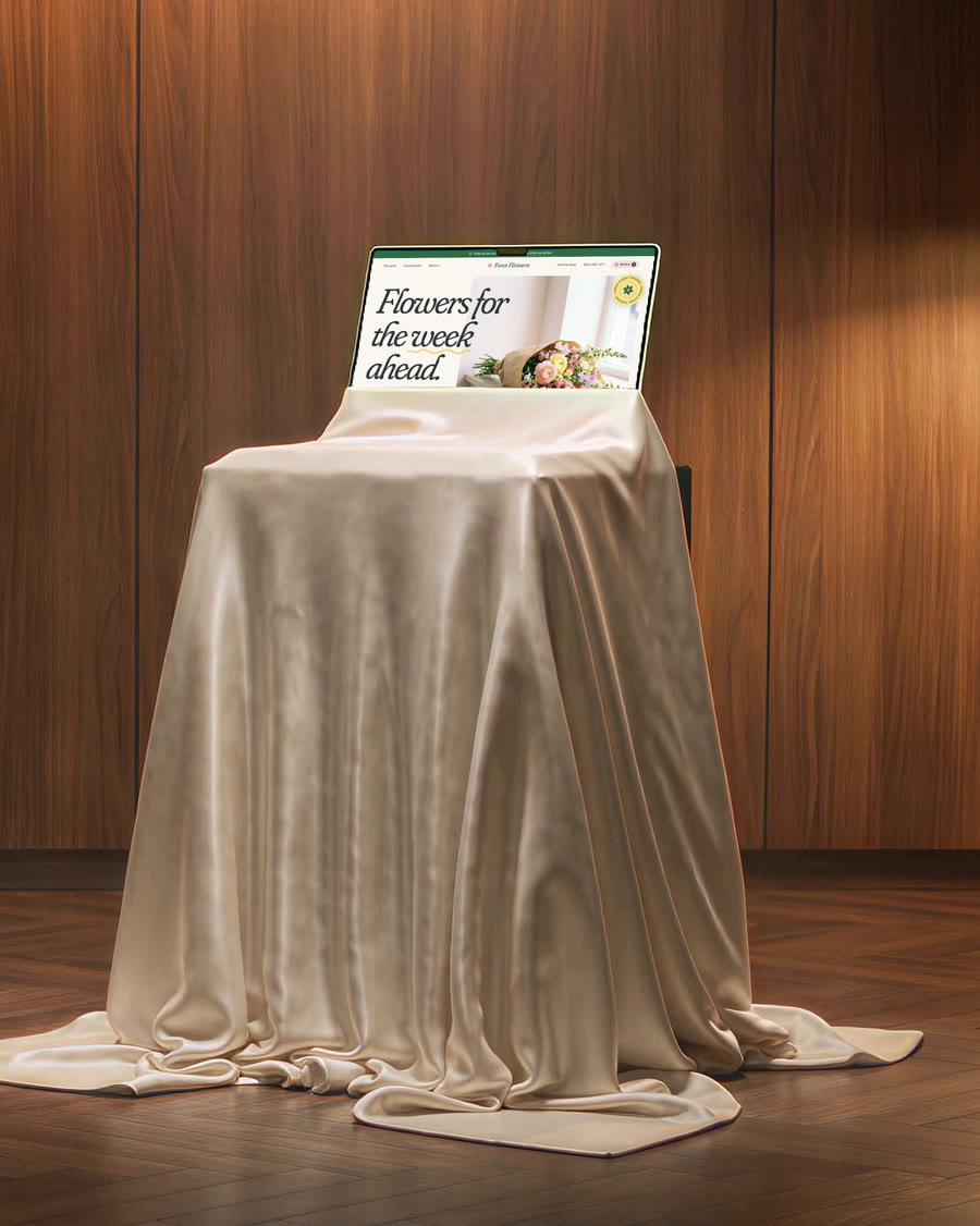 The cloth slipping down to show a laptop with a website on its screen.