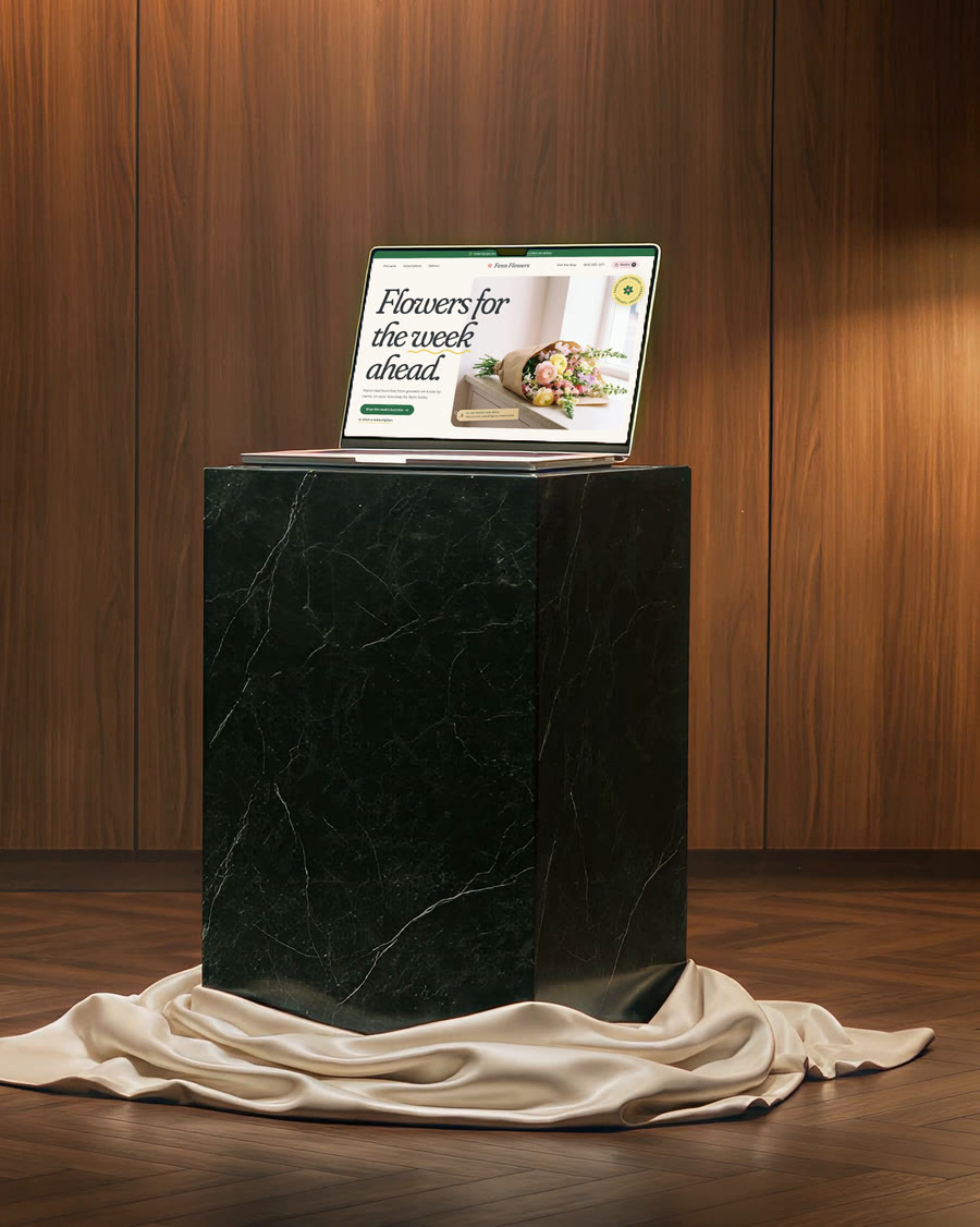 The laptop standing uncovered on a green marble pedestal, the cloth on the floor.
